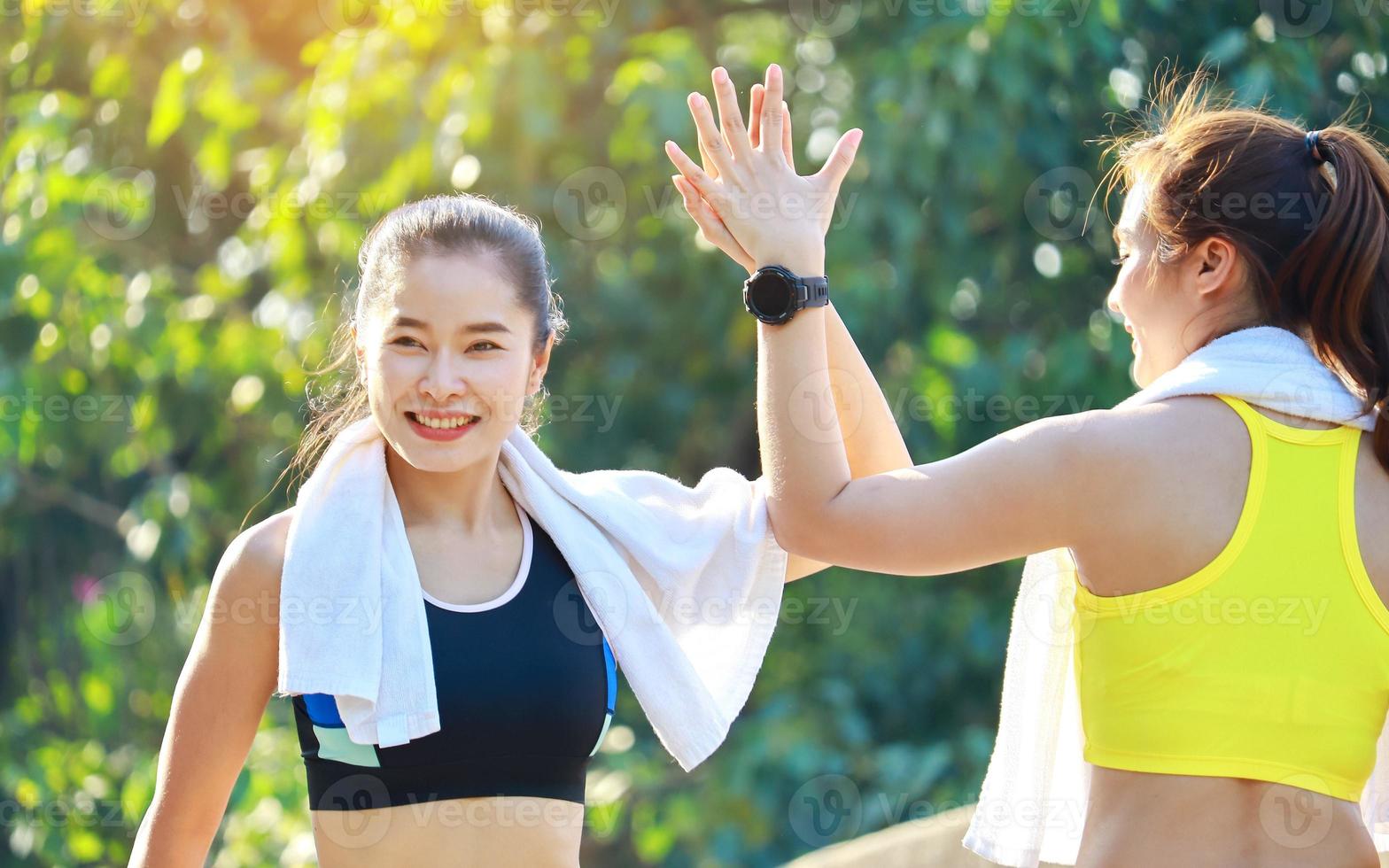 Two beautiful women exercising outdoors in the park photo