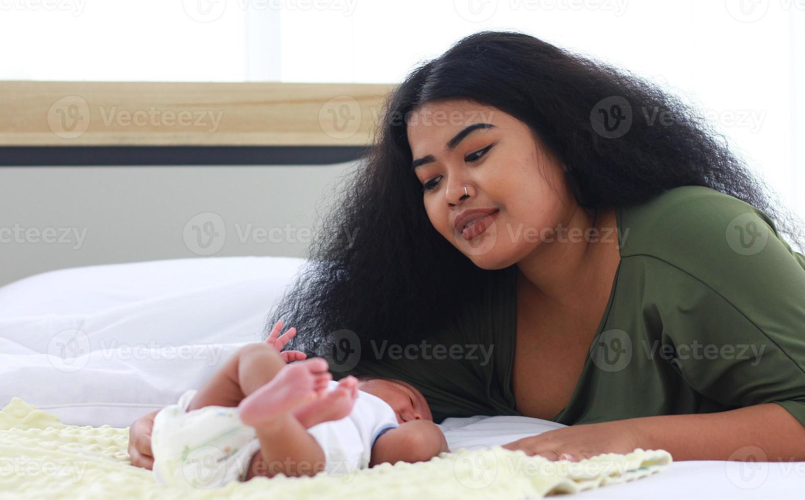 mamá disfruta jugando con su hijo recién nacido foto