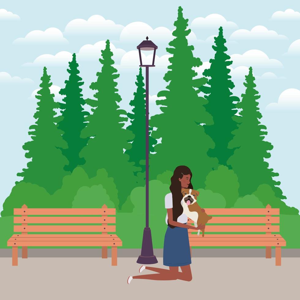 young afro woman lifting cute dog in the park vector