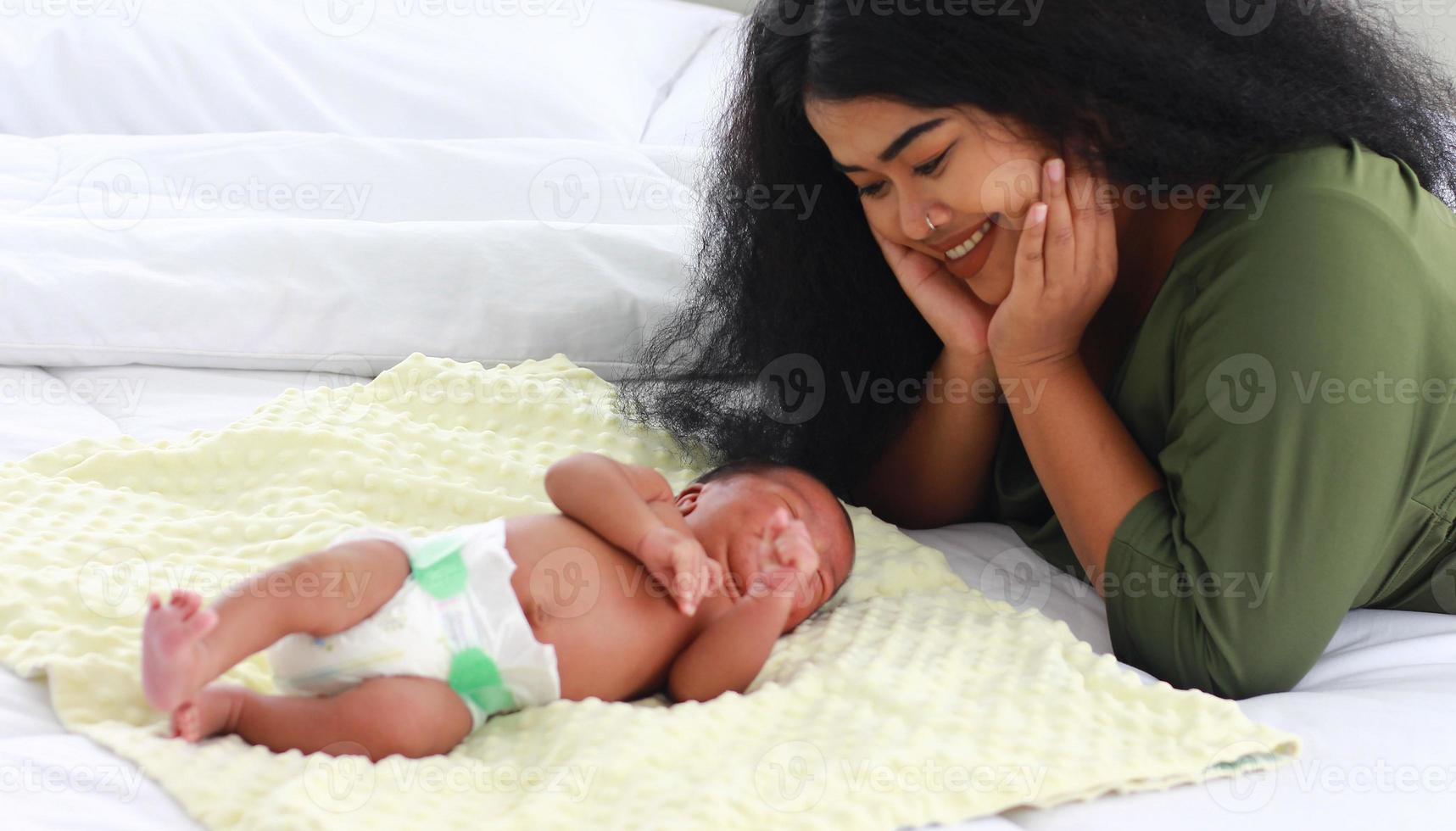 Mom enjoying playing with her newborn son photo