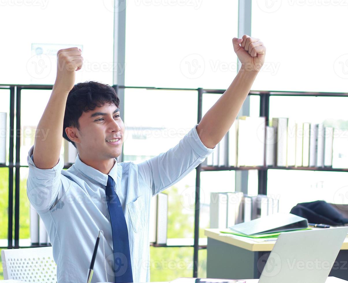 joven empresario trabajando felizmente en la oficina foto