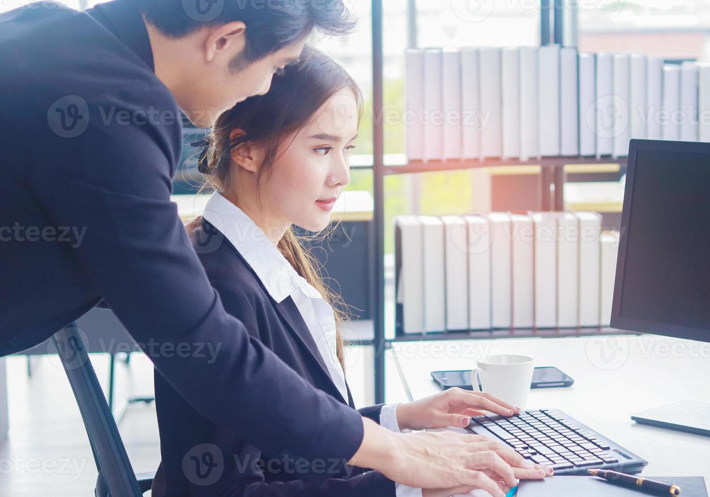 Mujer sentada y trabajando en la oficina siendo acosada sexualmente foto