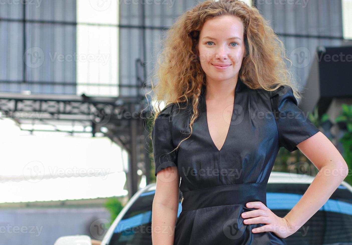 Beautiful young woman in the car showroom photo