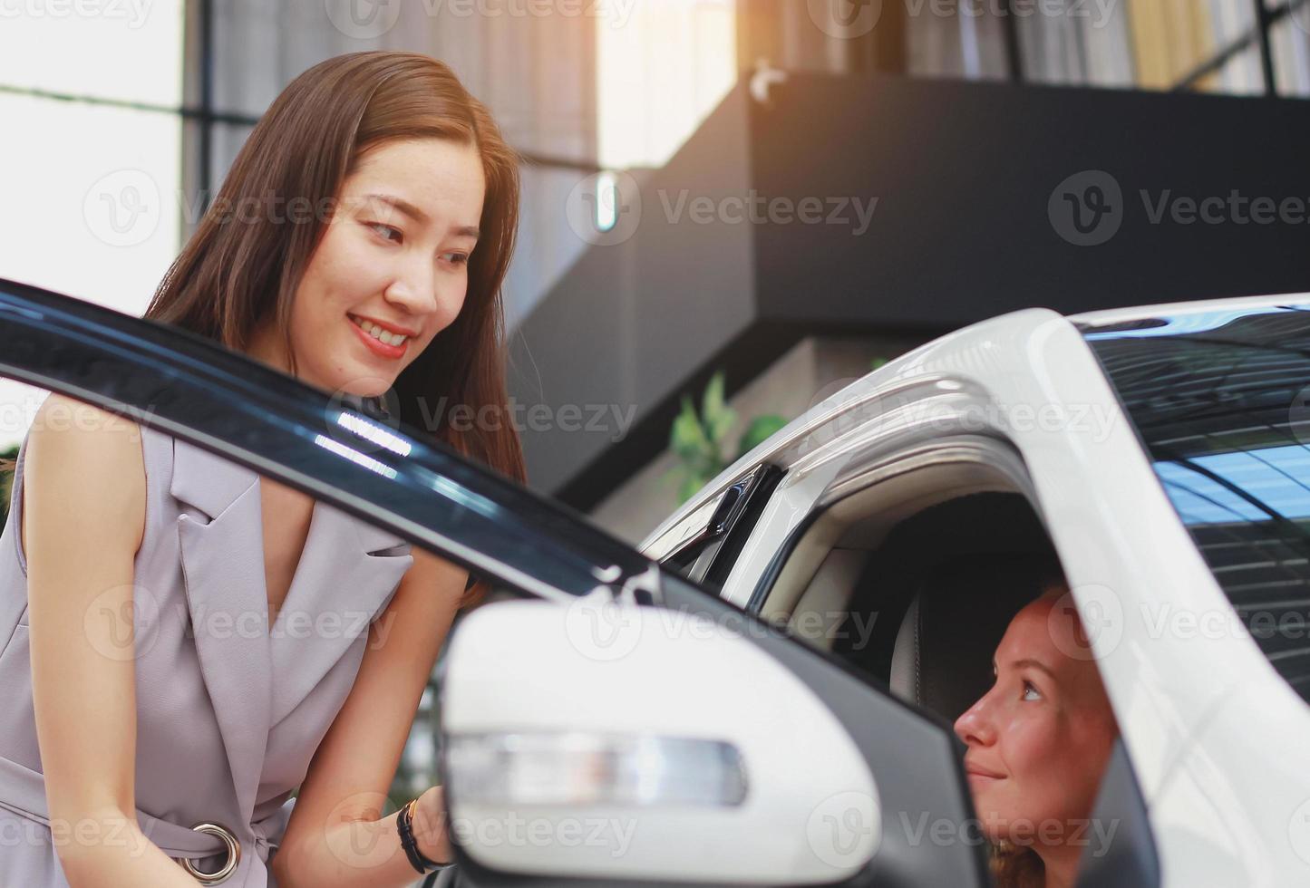 mujer compra un coche nuevo en una sala de exposiciones foto