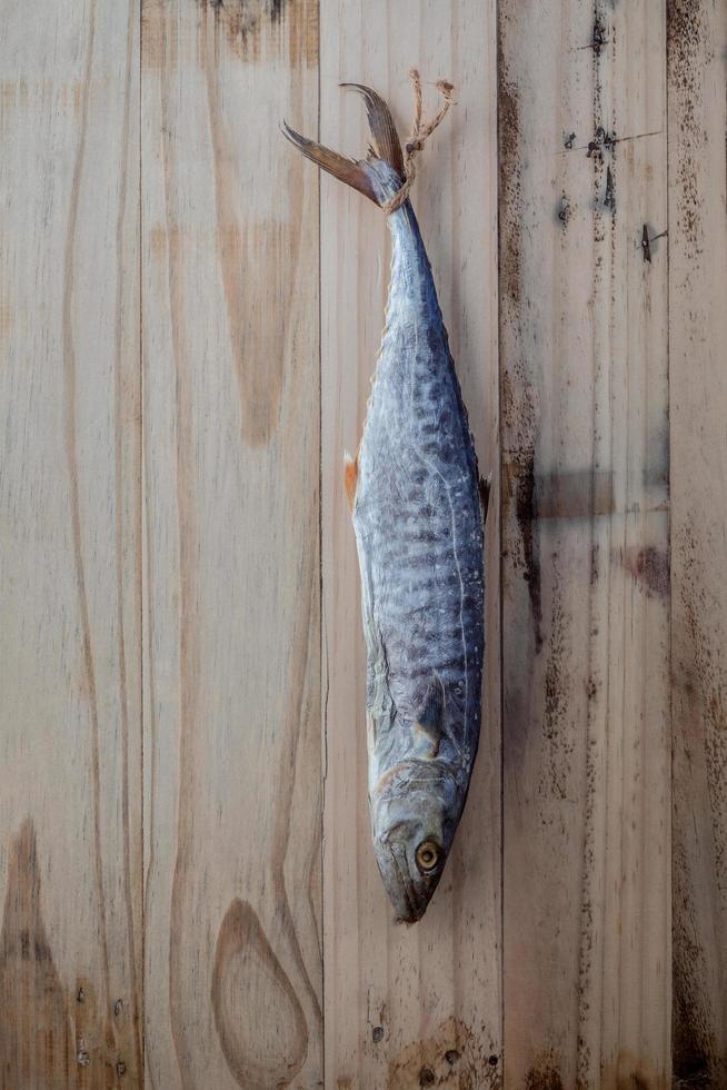 Pescado colgando para secar sobre un fondo de madera foto