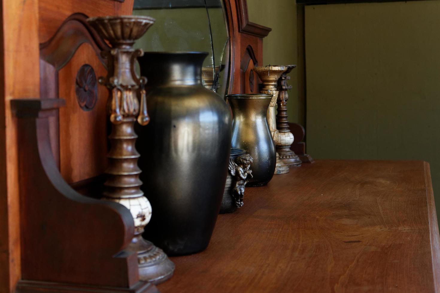 Vases and candlesticks next to a mirror on a dresser photo