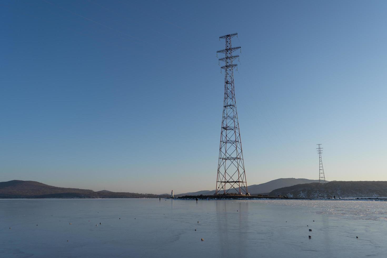 Paisaje marino de agua y montañas con torres de transmisión de electricidad en Vladivostok, Rusia foto