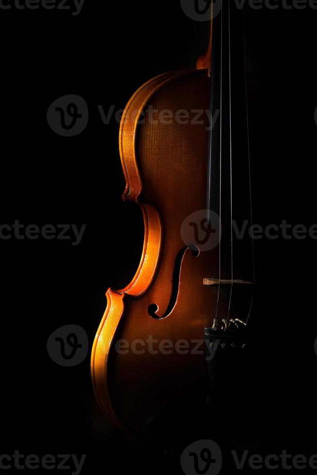 Violin detail on a black background between light or shadows photo