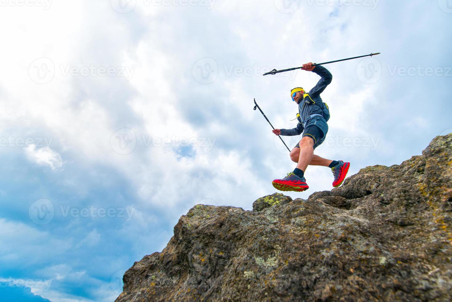 Atleta masculino cae de salientes rocosos durante el entrenamiento práctico en el sendero de montaña foto