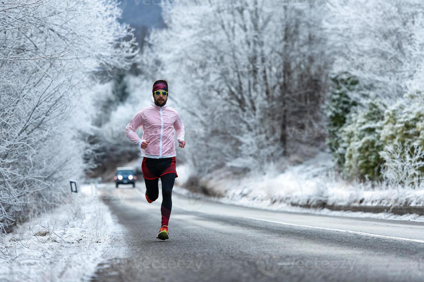 Young runner on ice cold road in the Alps photo