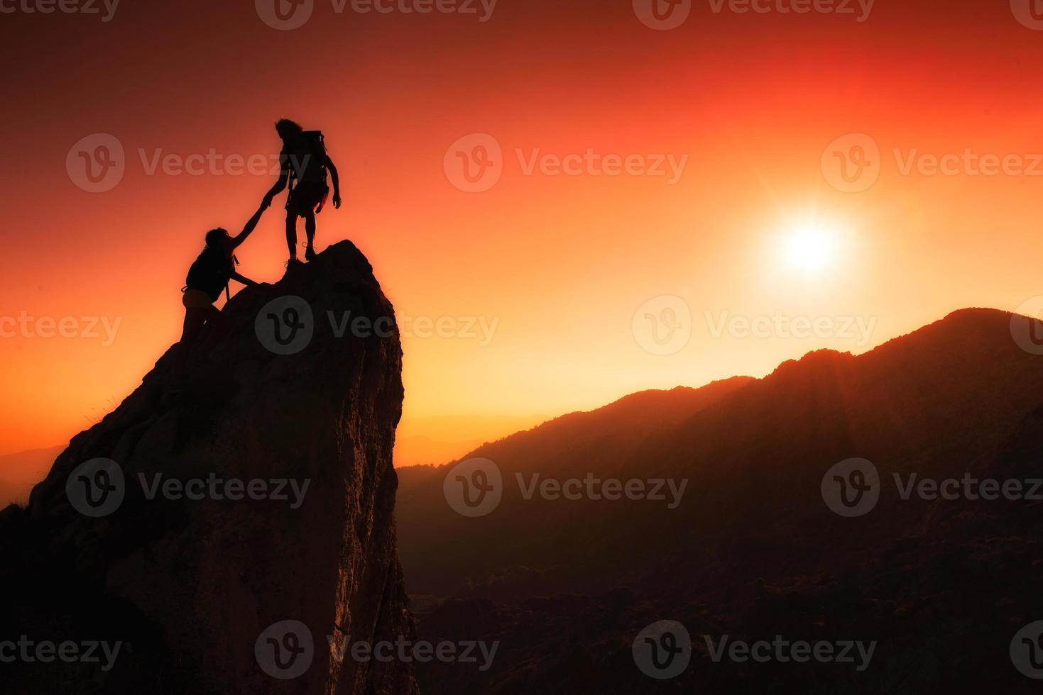 equipo de escaladores ayuda a conquistar la cumbre foto