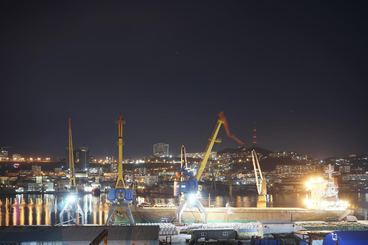 Night city landscape with view of a port and skyline in the background in Vladivostok, Russia photo