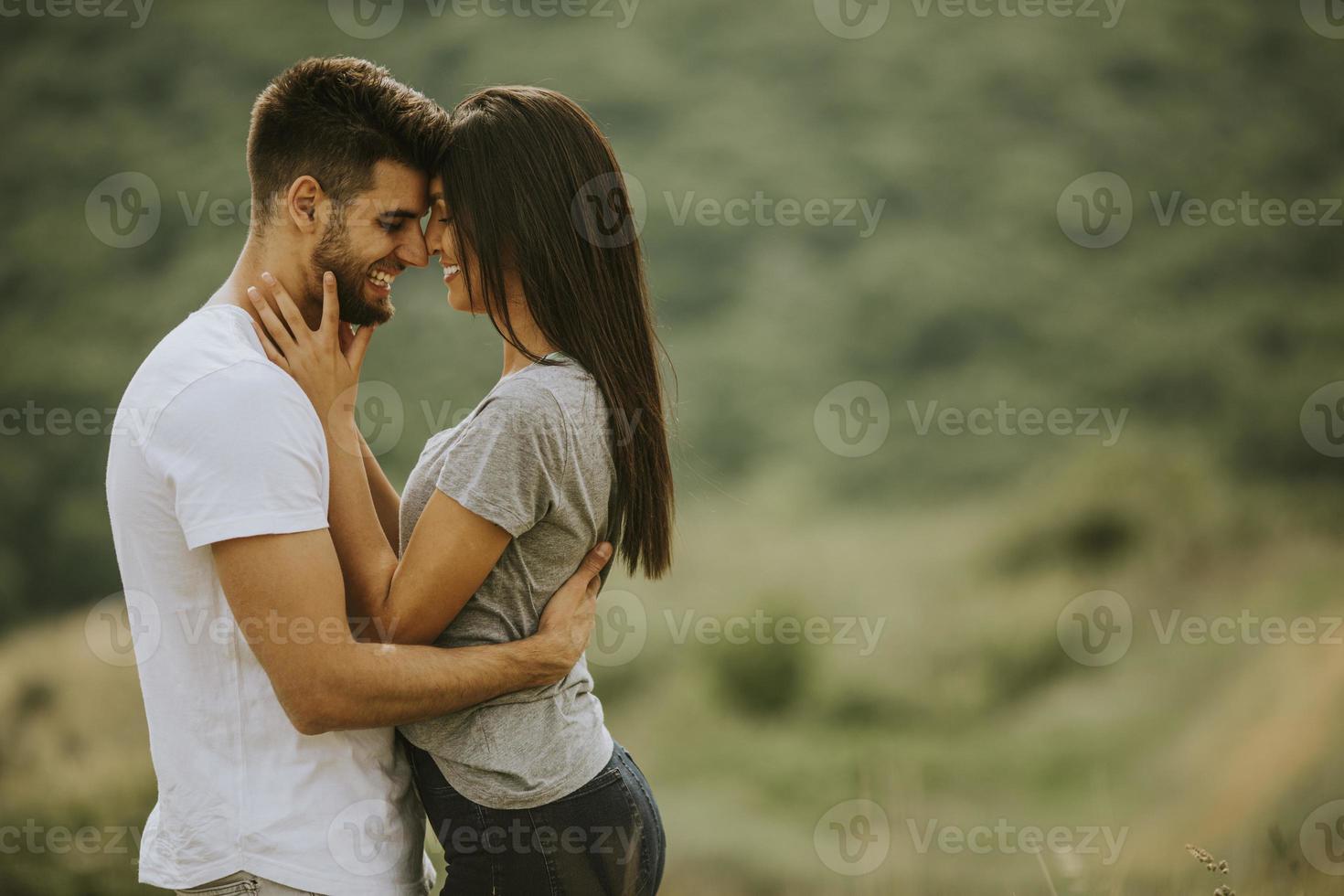 feliz, pareja joven, enamorado, en el campo de hierba foto