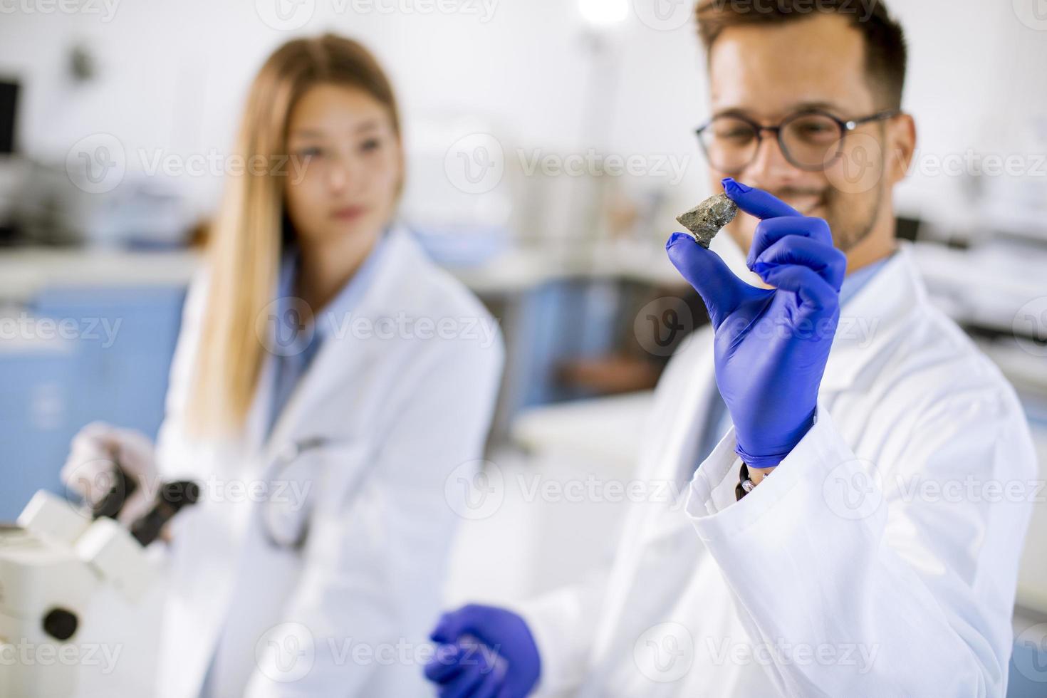 Group of young researchers analyzing chemical data in the laboratory photo