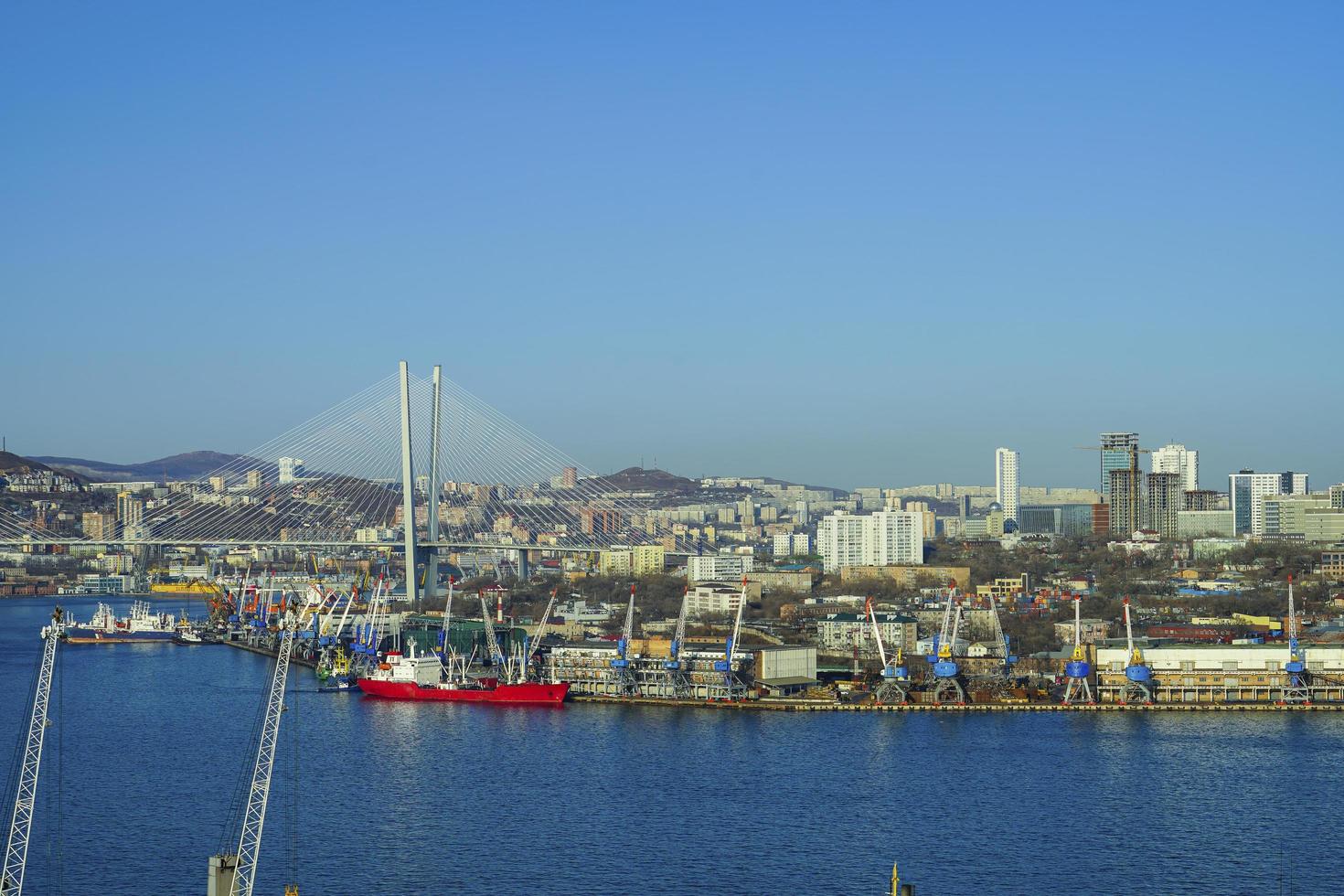 Paisaje urbano con cuerpo de agua y puerto con cielo azul claro en Vladivostok, Rusia foto