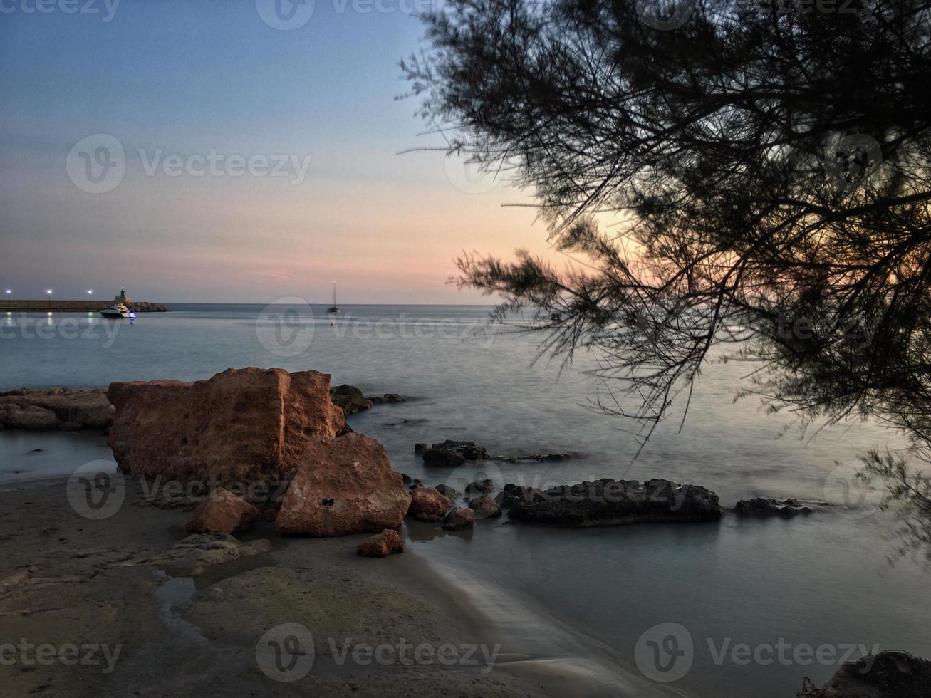 Playa mediterránea sin gente al atardecer en Calpe, Alicante foto