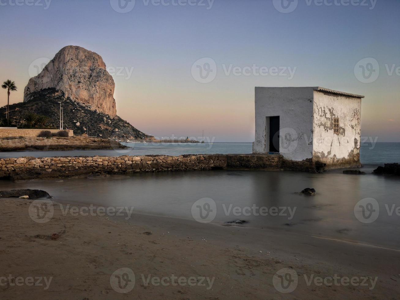 Playa mediterránea al atardecer con el peñón de fondo en Calpe, Alicante foto