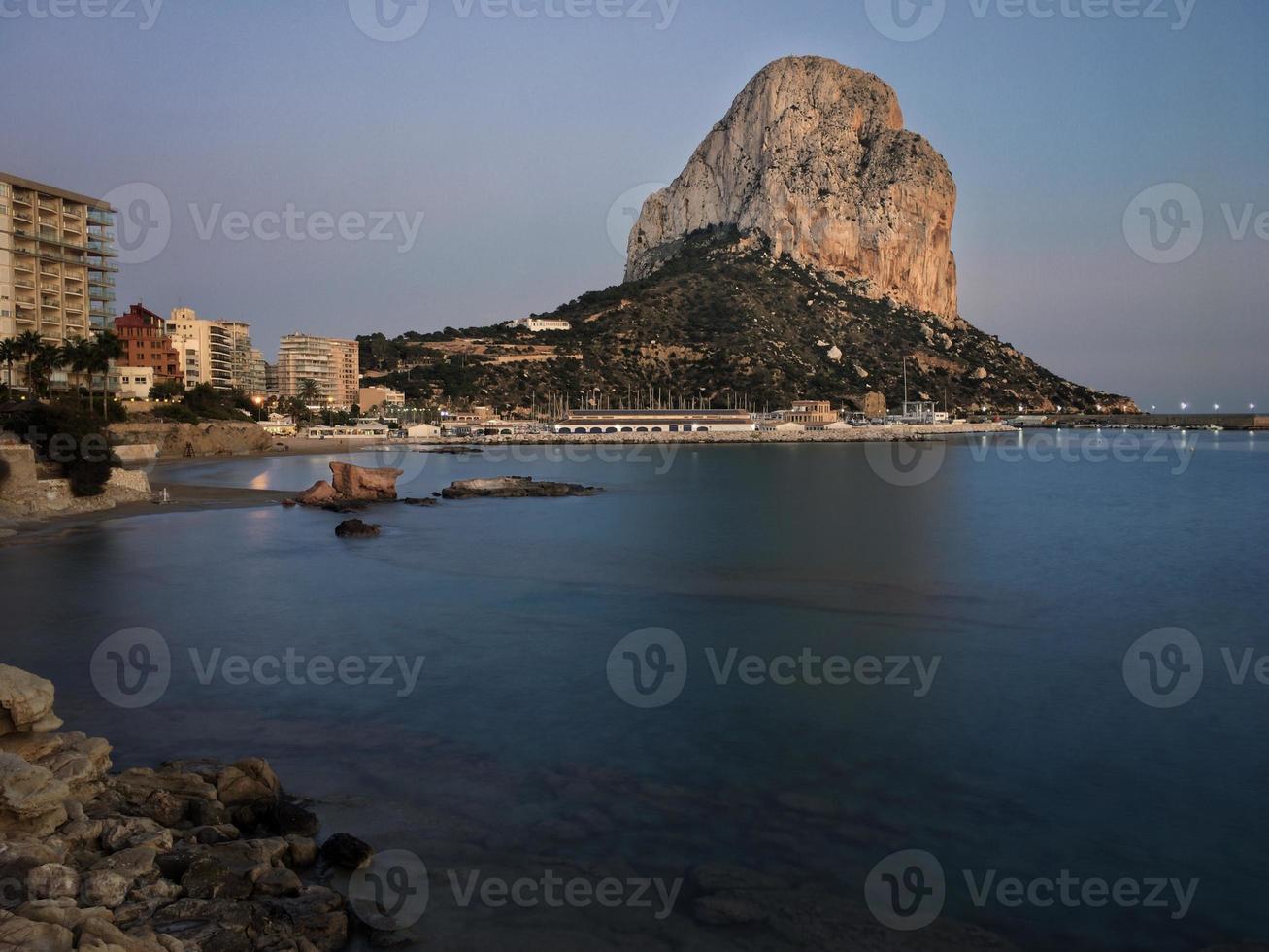 Playa mediterránea al atardecer con el peñón de fondo en Calpe, Alicante foto