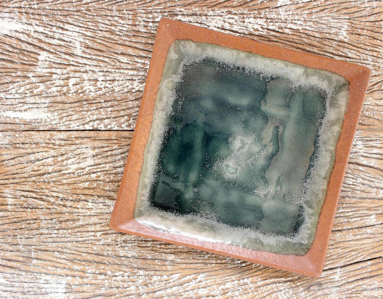 Top view of an empty ceramic plate on a wood table background photo