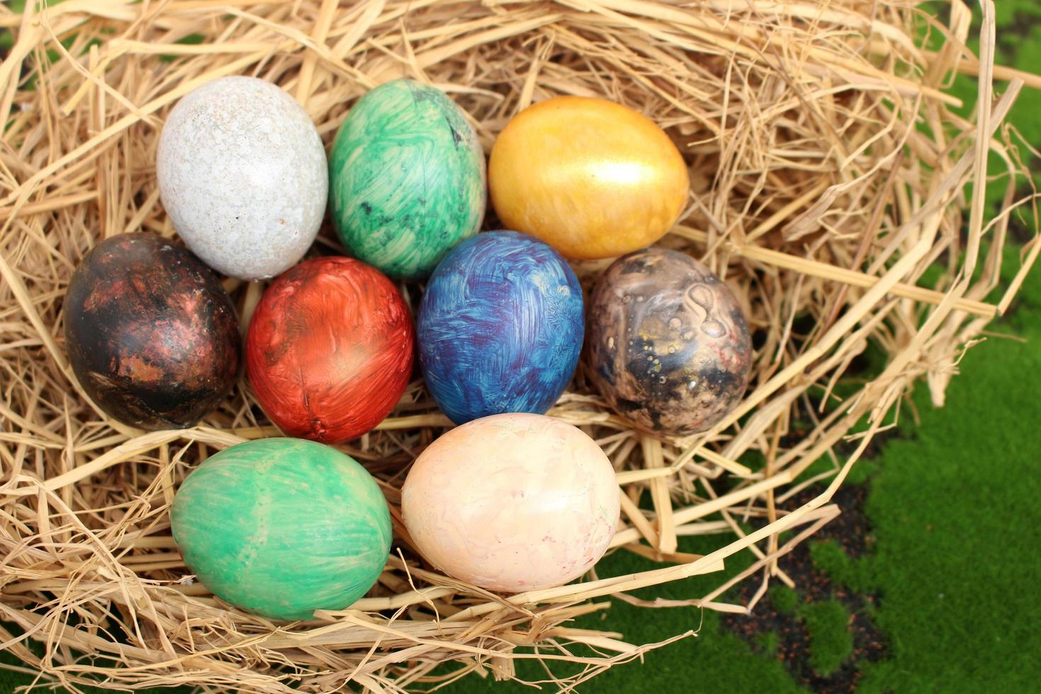 Straw basket with Easter eggs on a grass background photo