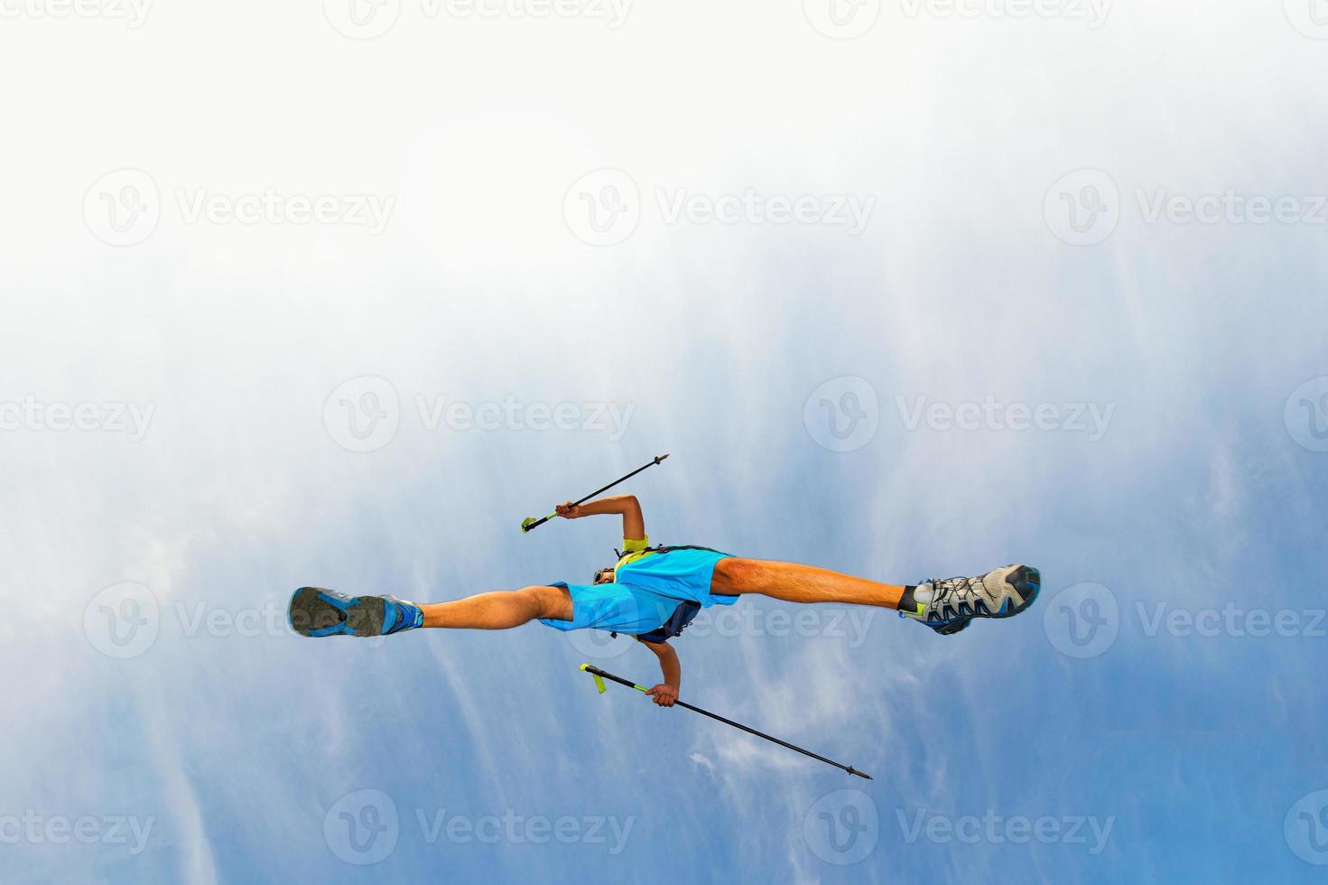 joven atleta hace un salto con bastones nórdicos foto