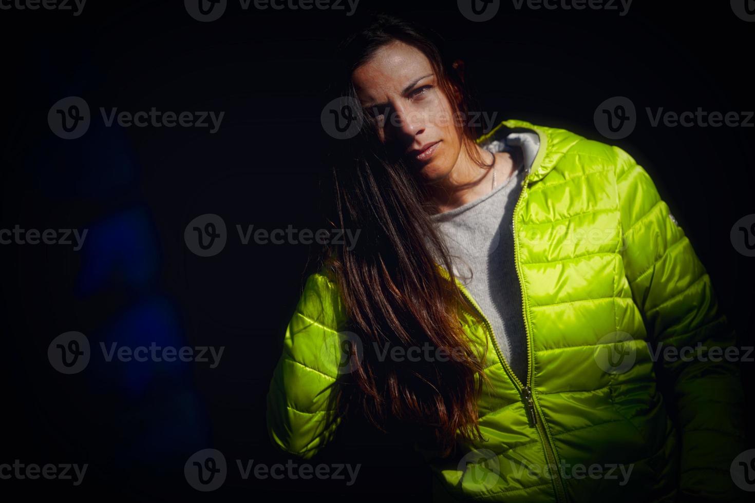Girl model with green jacket on a black background photo