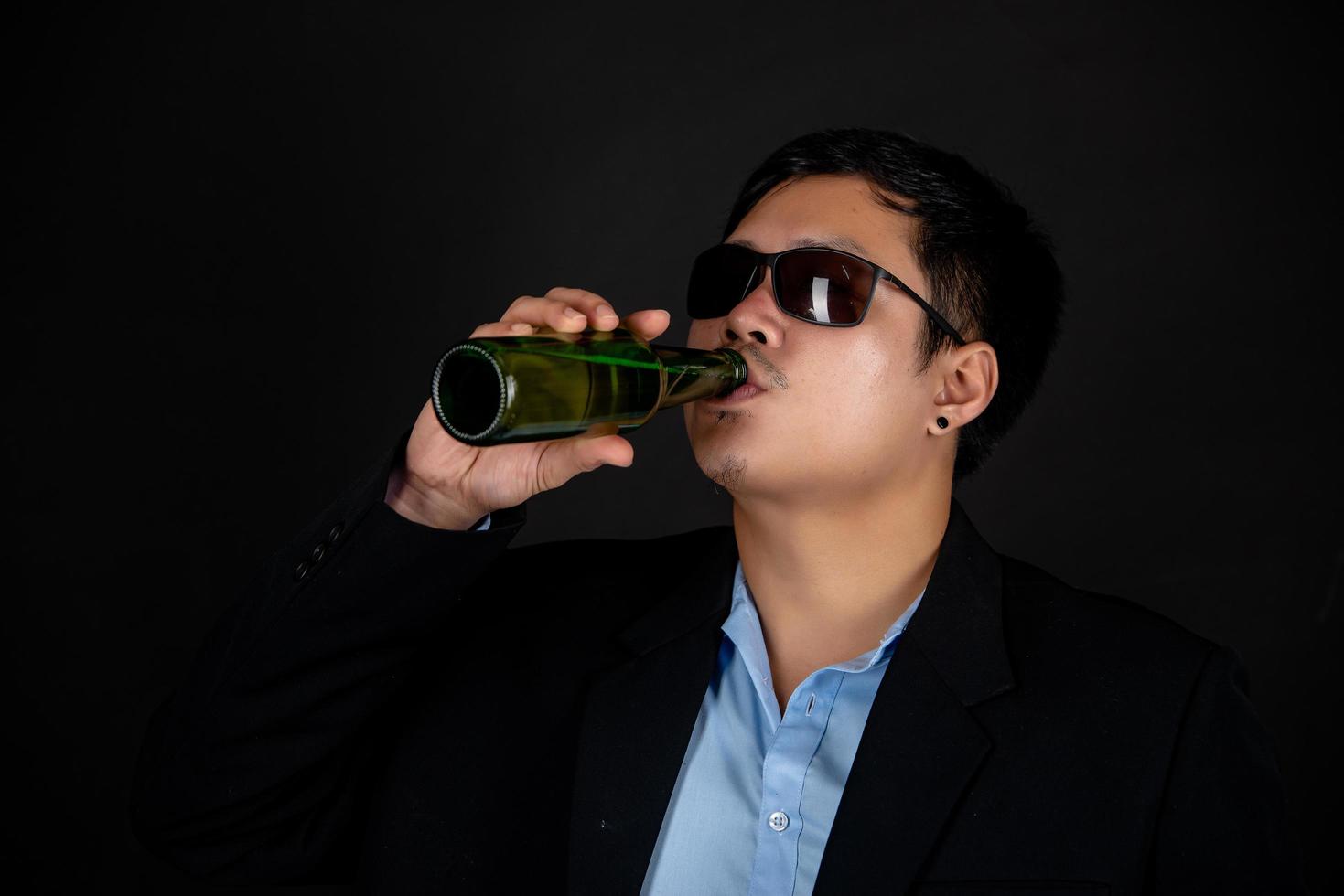 Cropped close-up of a man drinking beer at home photo