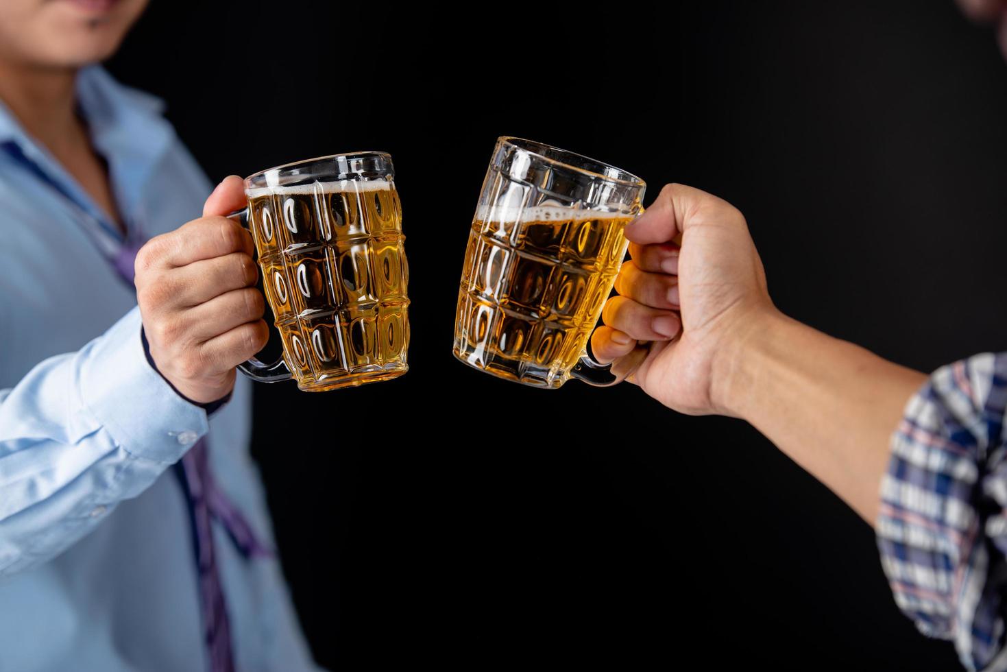 Cropped image of handsome friends clinking bottles of beer at home photo