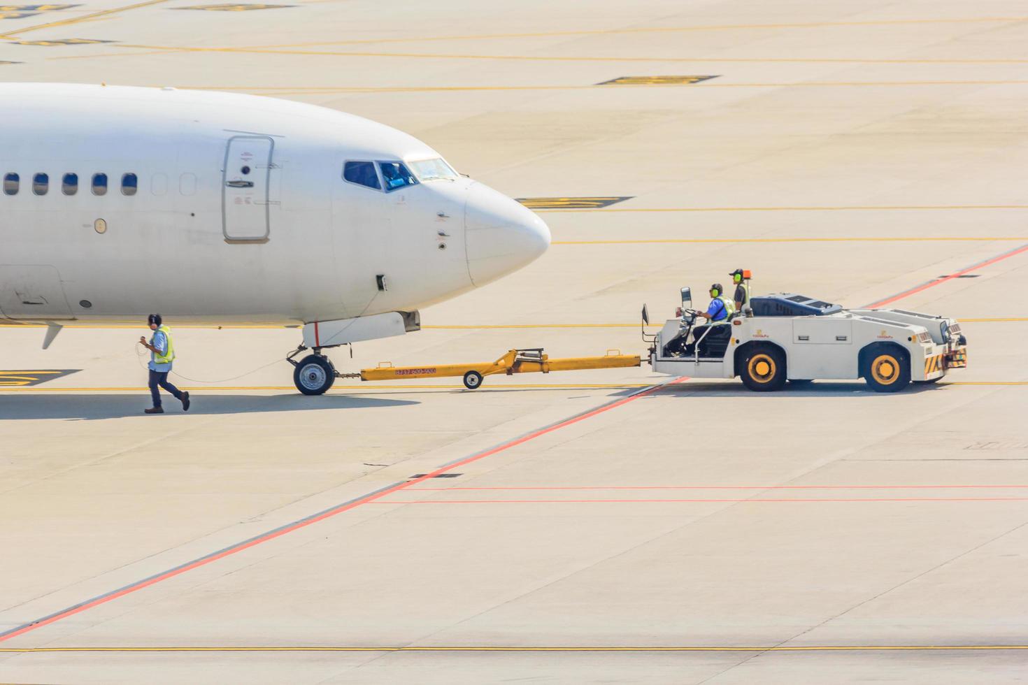 Airplane tow truck towing aircraft on the runway photo