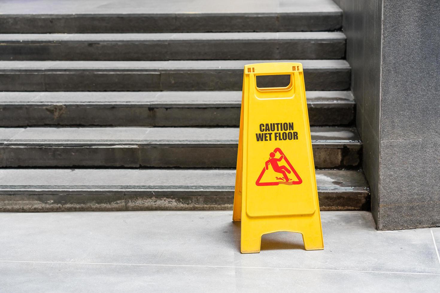 piso del vestíbulo con cubo de fregona y señal de precaución piso húmedo foto