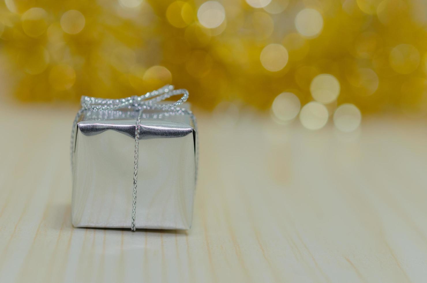 Silver gift against a gold background photo