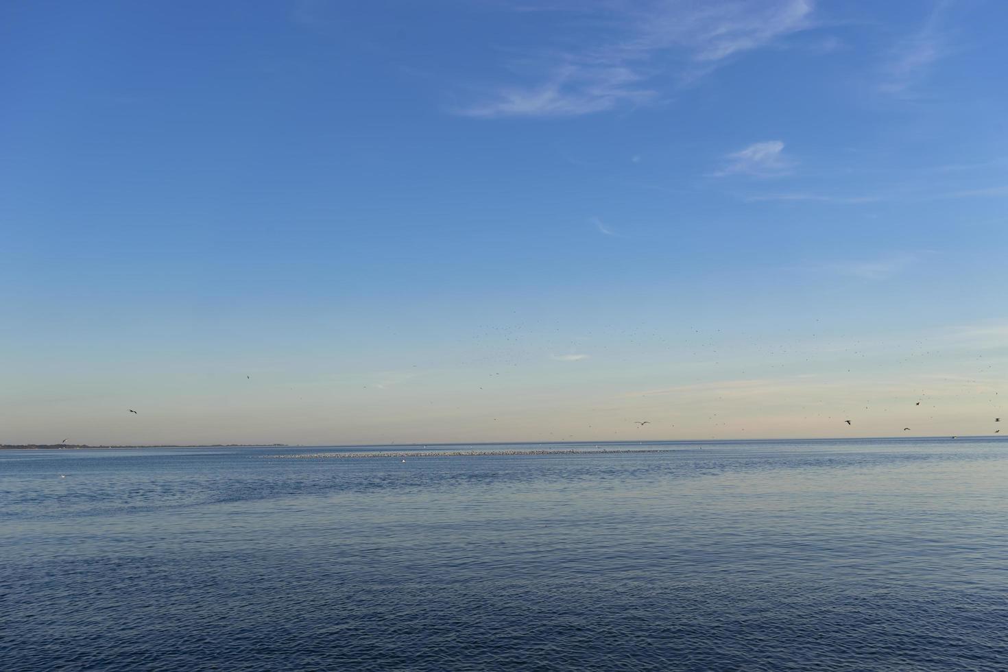 Paisaje marino de un cuerpo de agua con horizonte colorido y cielo azul foto