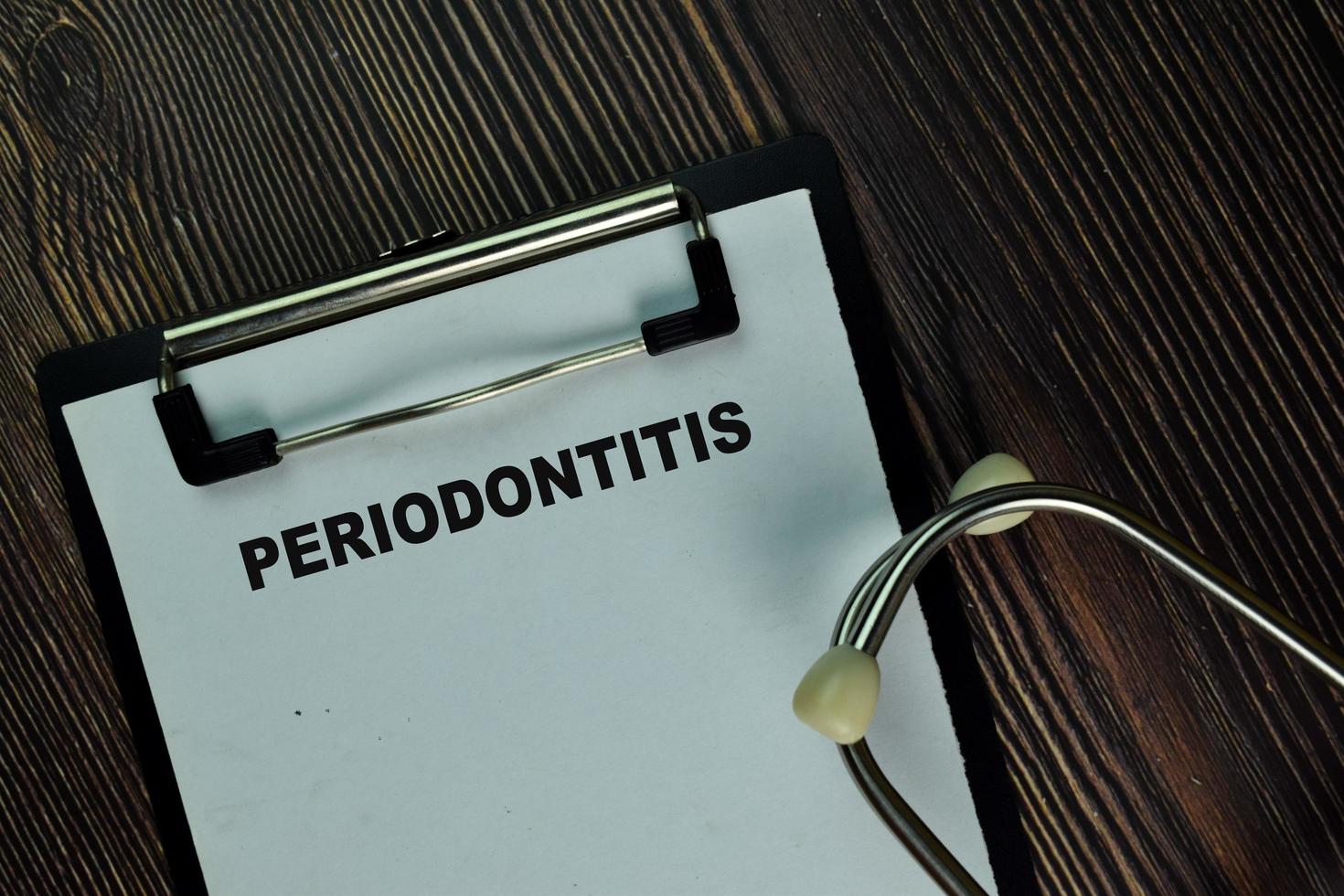 Periodontitis written on a paperwork isolated on wooden table photo