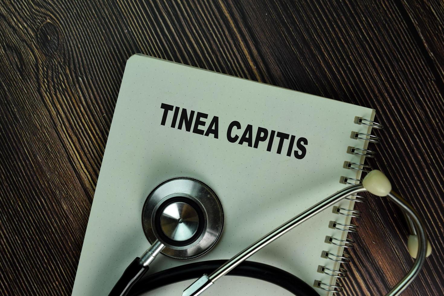 Tinea Capitis written in a book isolated on wooden table photo