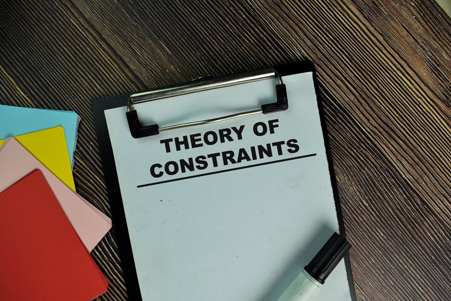 Theory Of Constraints written on paperwork isolated on wooden table photo