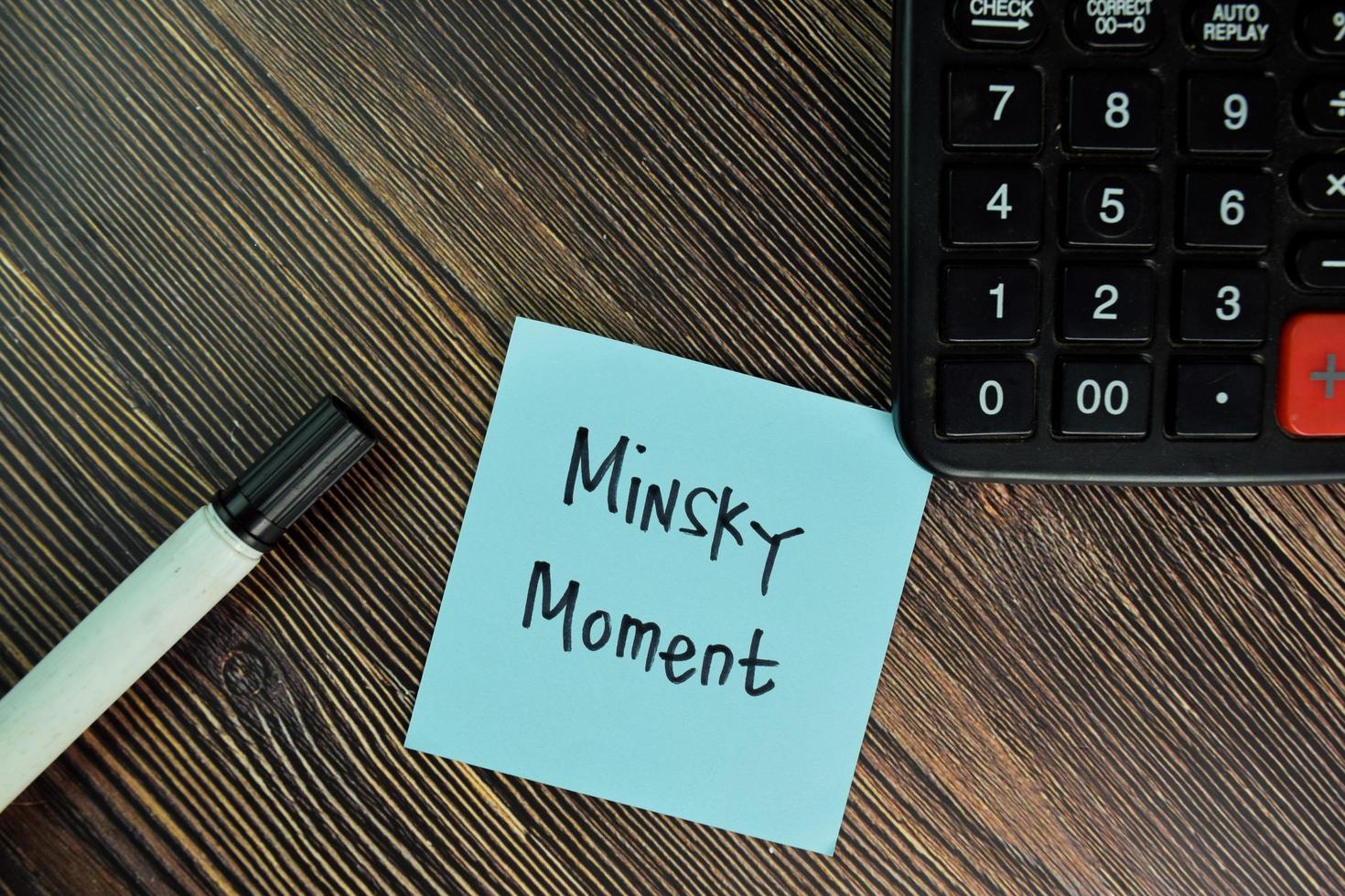 Minsky Moment written on sticky note isolated on wooden table photo