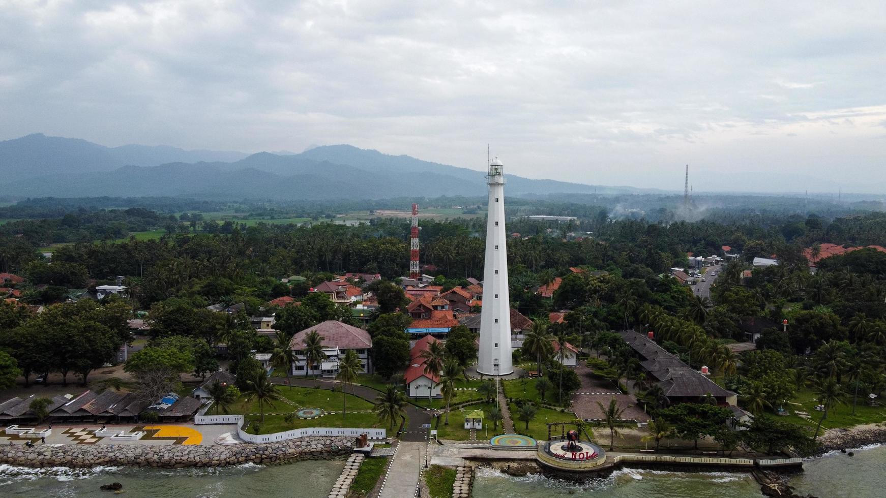 banten, indonesia 2021 - vista aérea del paisaje de la puesta del sol de la roca del mar del faro foto