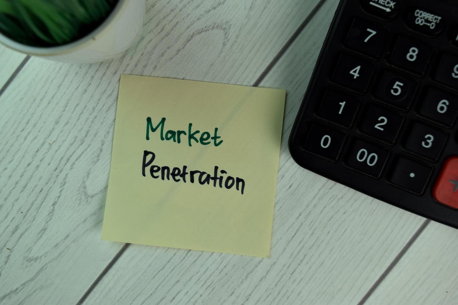 Penetración de mercado escrito en nota adhesiva aislado sobre mesa de madera foto