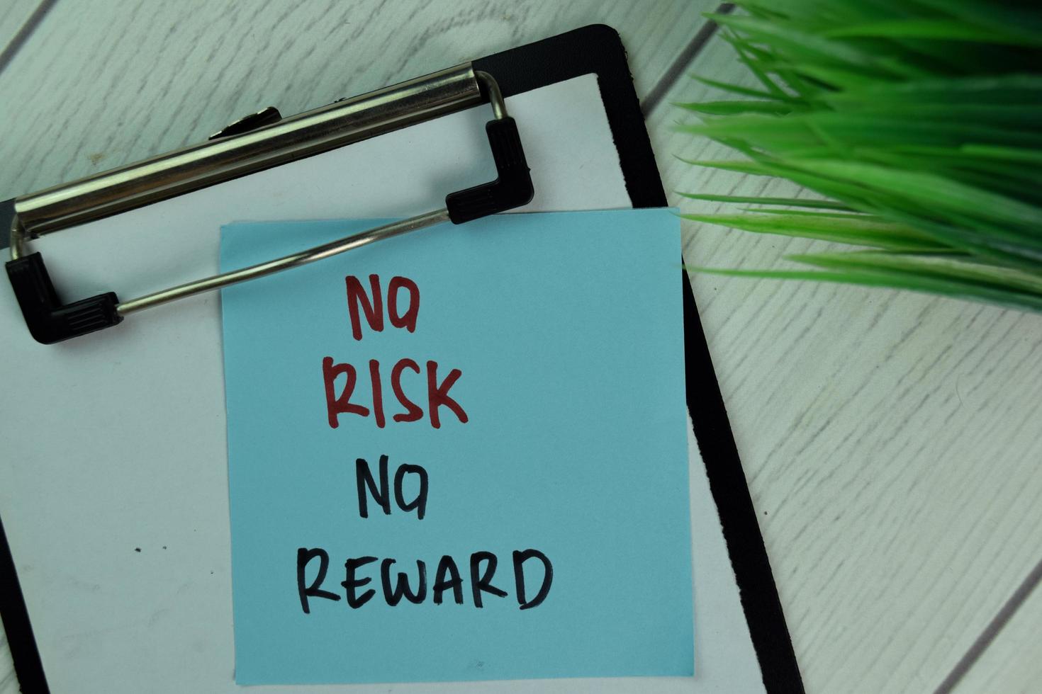 No Risk No Reward written on sticky note isolated on wooden table photo