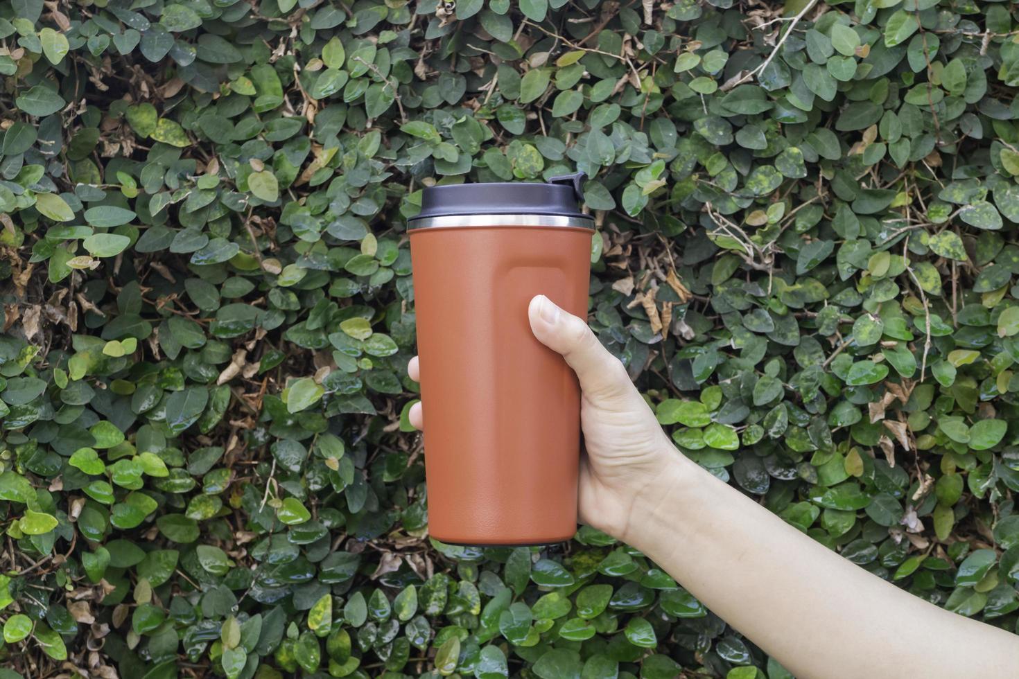 Aluminum thermos mug in hand photo