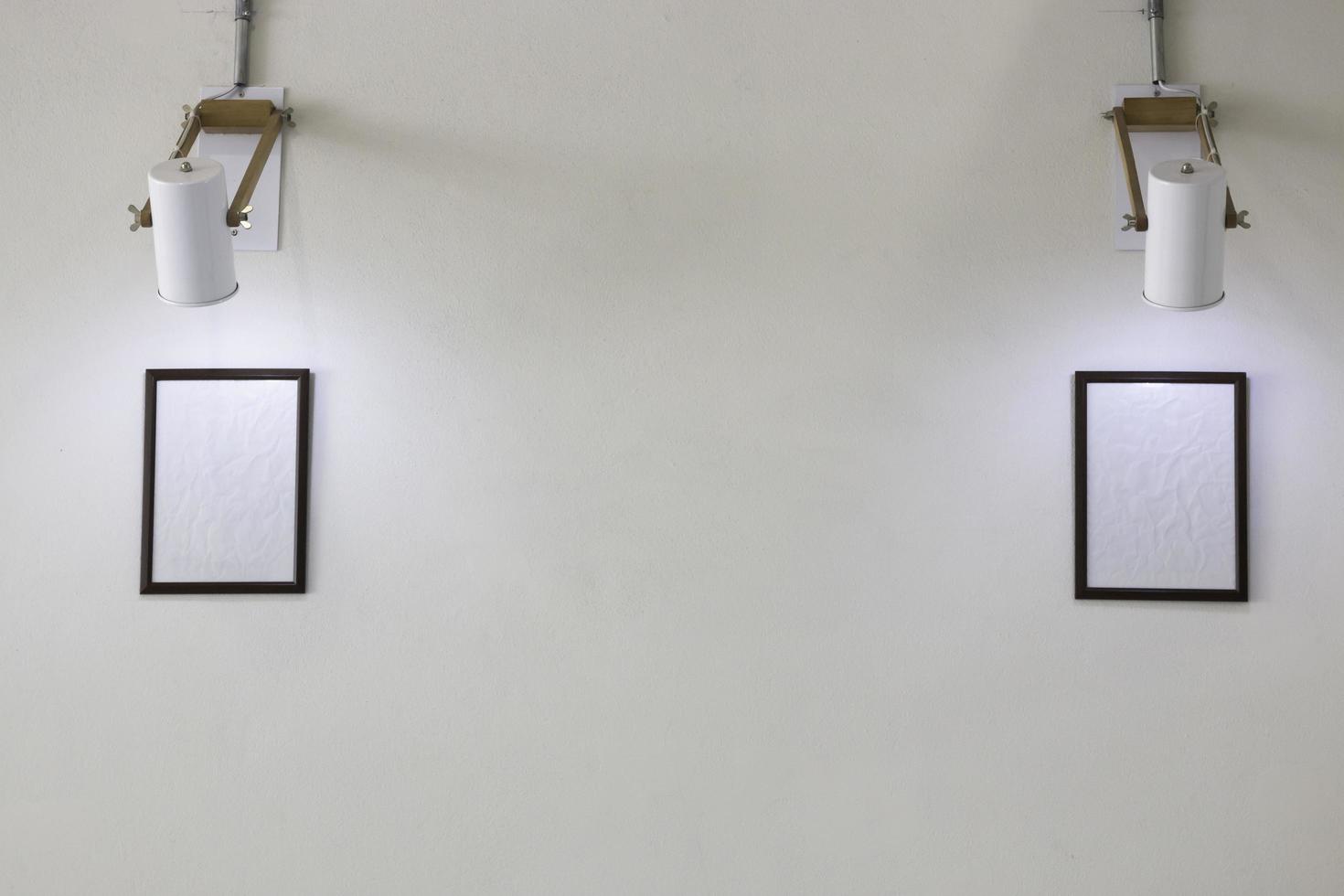 Two empty picture frames on white wall photo