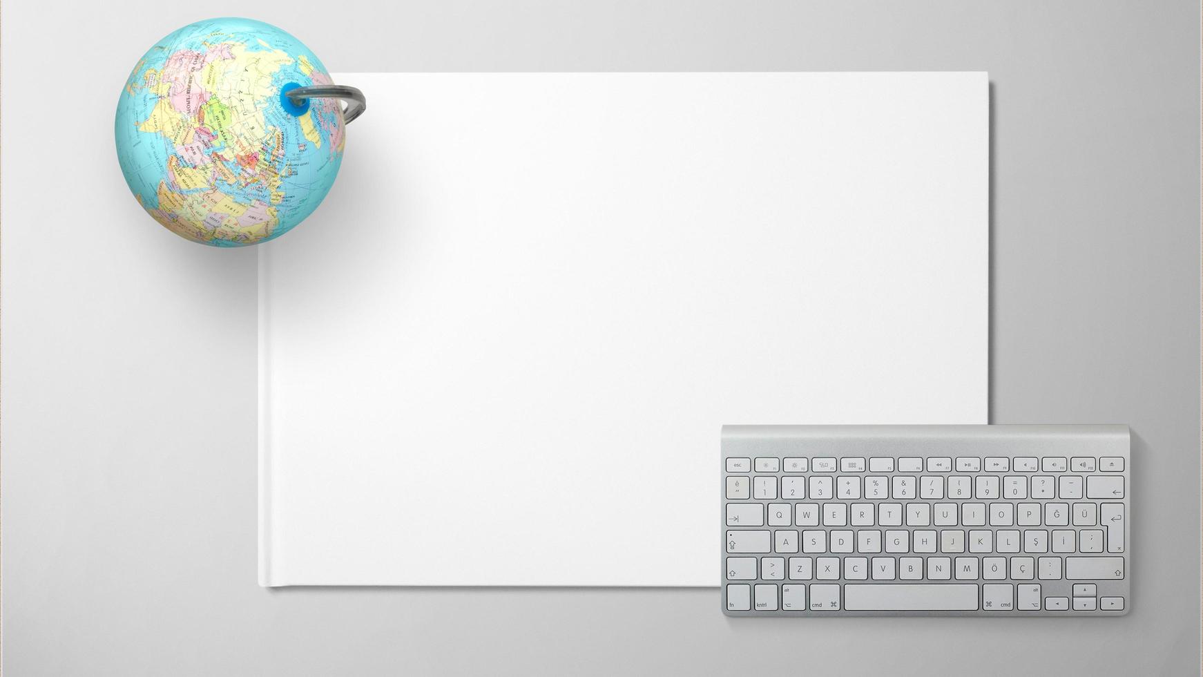 Globe with computer keyboard on white paper on isolated background photo