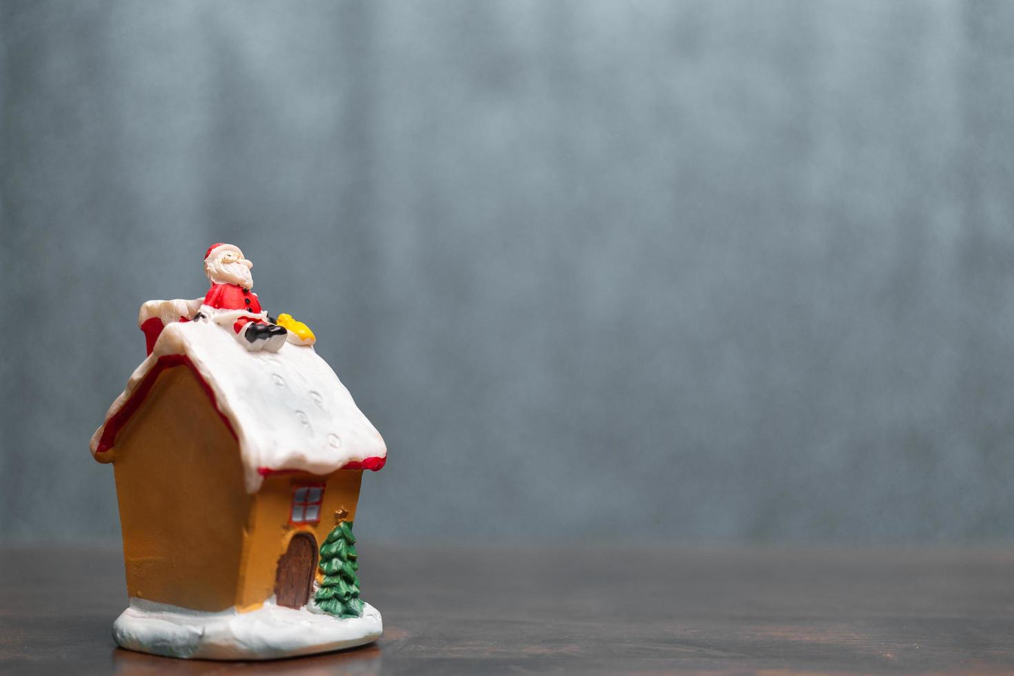 Papá Noel en miniatura sentado en un techo, leyenda navideña y felices fiestas concepto foto