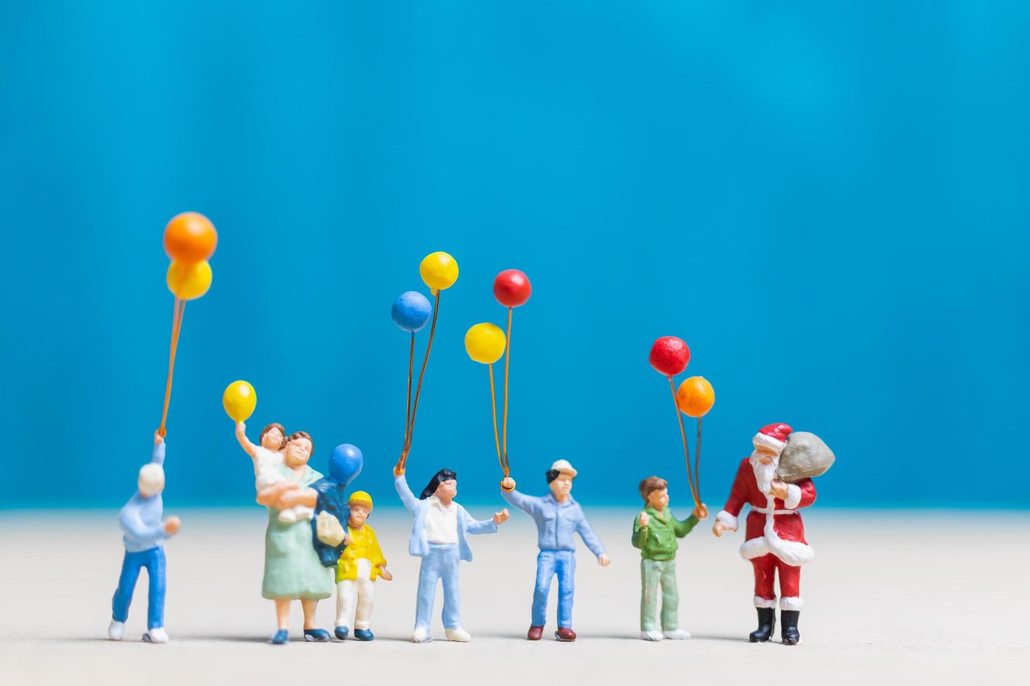 Papá Noel en miniatura y niños sosteniendo globos, feliz navidad y feliz año nuevo concepto foto