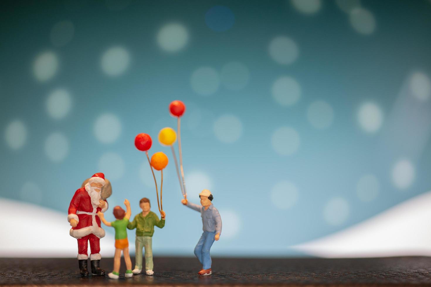 Papá Noel en miniatura y niños sosteniendo globos, feliz navidad y feliz año nuevo concepto foto