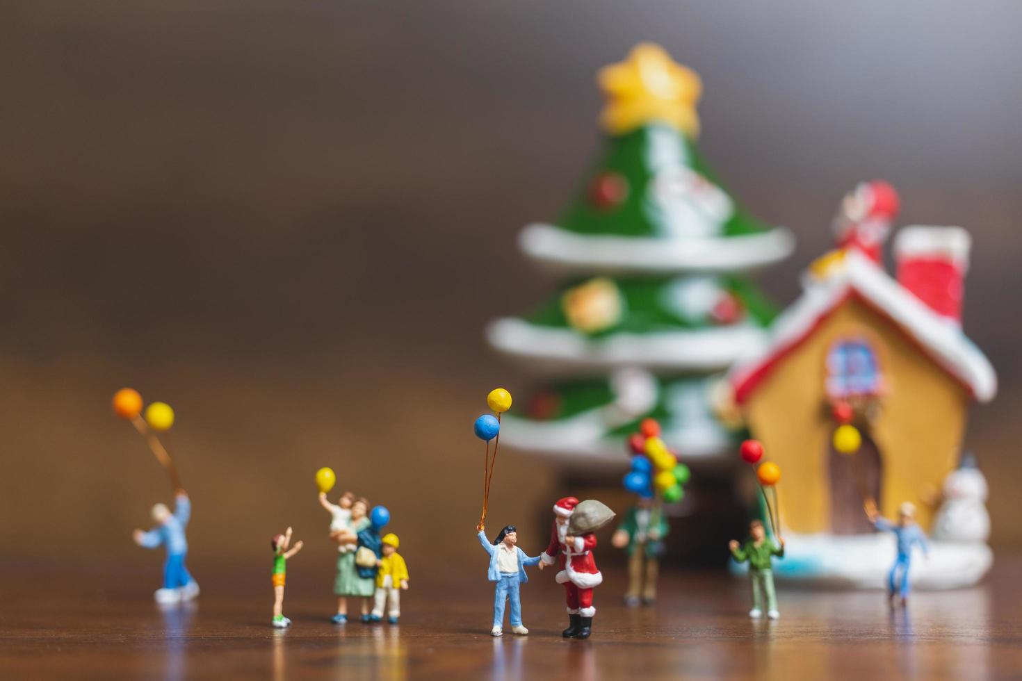 Papá Noel en miniatura y niños sosteniendo globos, feliz navidad y feliz año nuevo concepto foto