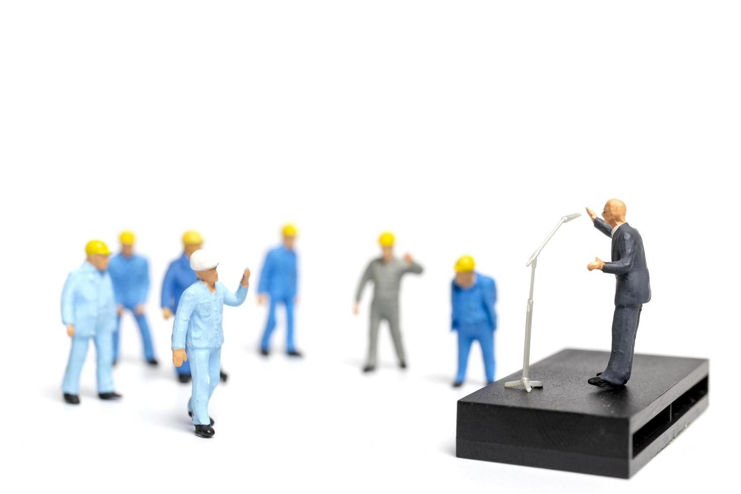 Miniature people listening to a politician speaking during an election rally photo