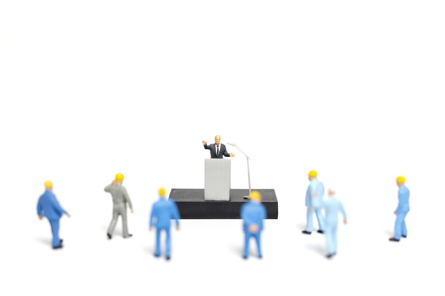 Miniature people listening to a politician speaking during an election rally photo