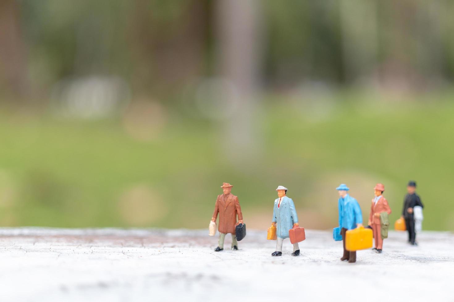 Viajeros en miniatura caminando por una calle, concepto de viaje y aventura. foto