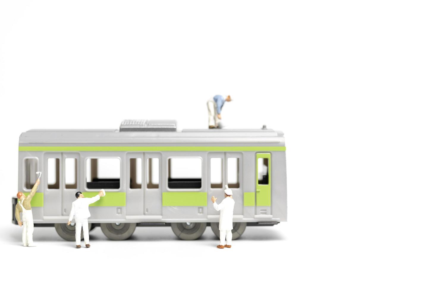 Miniature painters painting a train on a white background, repairing concept photo